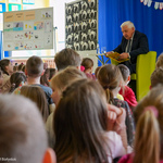 Prezydent Tadeusz Truskolaski czyta książkę dzieciom siedzącym na podłodze