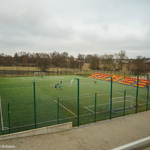 Boisko szkolne, na którym dzieci grają w piłkę nożną 