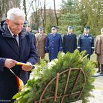 Prezydent Tadeusz Truskolaski poprawia wstęgę znajdującą się na wieńcu kwiatowym 