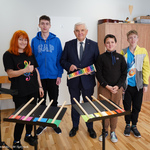 Prezydent Tadeusz Truskolaski wraz z uczniami trzymającymi w dłoniach instrumenty