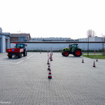 Dwa traktory stoją na parkingu szkolnym