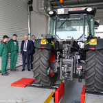 Prezydent Tadeusz Truskolaski rozmawia z dwójką uczniów podczas zajęć praktycznych, obok stoi duży traktor