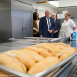 Hot dogi przygotowane dla uczniów, w tle: Prezydent Tadeusz Truskolaski oraz kadra szkolna