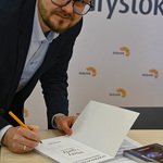 Dr Adam Hermaniuk podczas podpisywania książki 