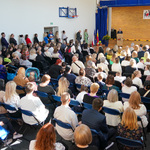 Goście wydarzenia siedzą na sali gimnastycznej 