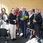 Prezydent Tadeusz Truskolaski trzyma w dłoni bukiet tulipanów, dookoła stoją kobiety z kwiatami 