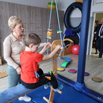 Kobieta prowadzi ćwiczenia rehabilitacyjne z chłopcem
