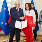 Kobieta ubrana w biało-czerwony dres otrzymuje z rąk prezydenta Tadeusza Truskolaskiego stypendium oraz list gratulacyjny