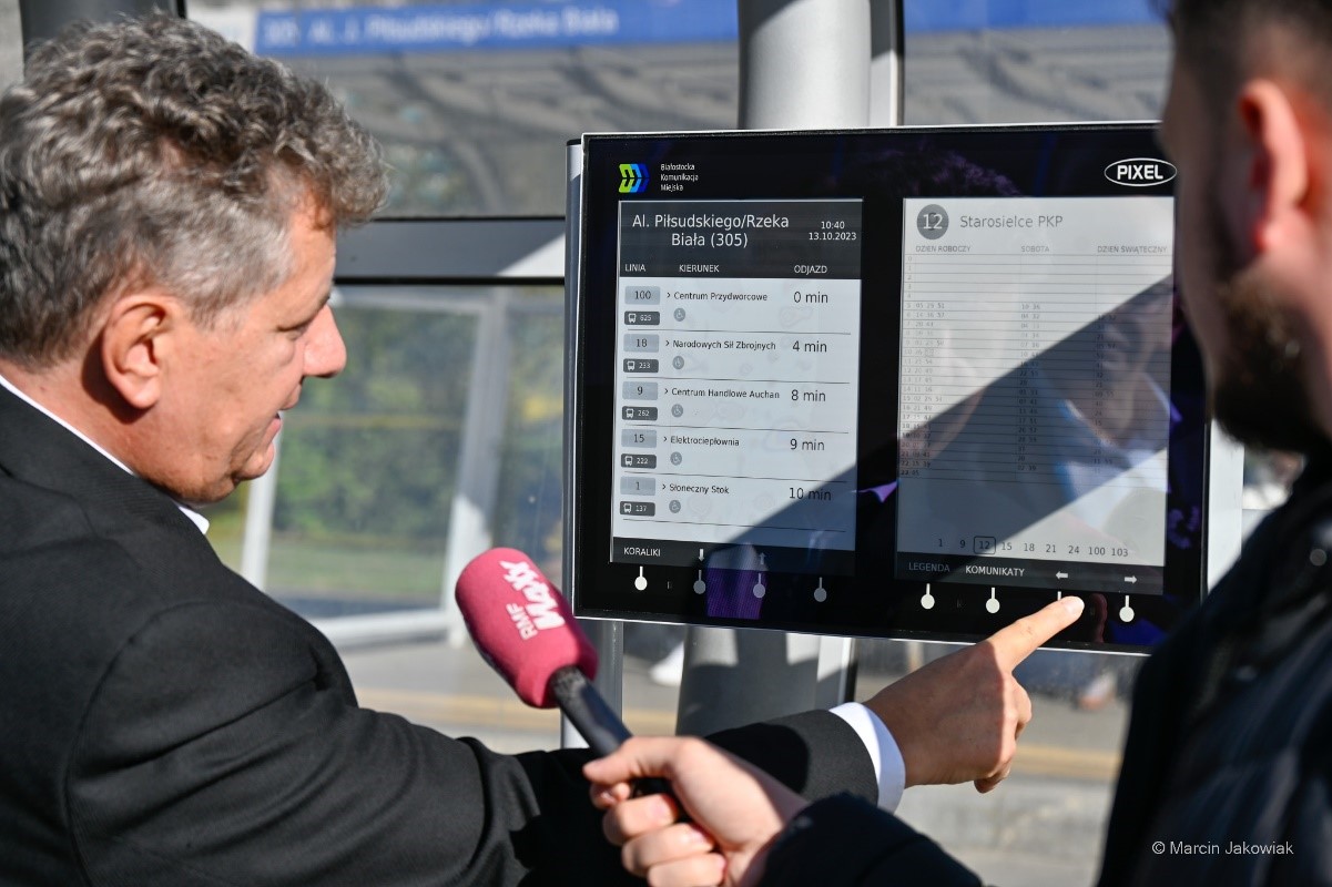 dyrektor Bogusław Prokop prezentuje dziennikarzowi elektroniczną tablicę informacyjną
