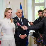 Młoda kobieta stojąca obok Prezydenta Tadeusza Truskolaskiego odpowiada na pytania dziennikarzy
