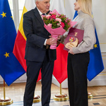 Prezydent Truskolaski wręcza bukiet kwiatów kobiecie