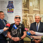 Przedstawiciel Galerii Marchand Krzysztof Koniczek udziela wywiadu do mikrofonów ustawionych na pierwszym planie. Obok stoi Zastępca Prezydenta Rafał Rudnicki, Prezydent Tadeusz Truskolaski oraz reporterzy