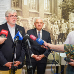 Dyrektor Muzeum Wojska Polskiego Rober Sadowski udziela wywiadu, obok stoi Prezydent Tadeusz Truskolaski. Na pierwszym planie ustawione są mikrofony