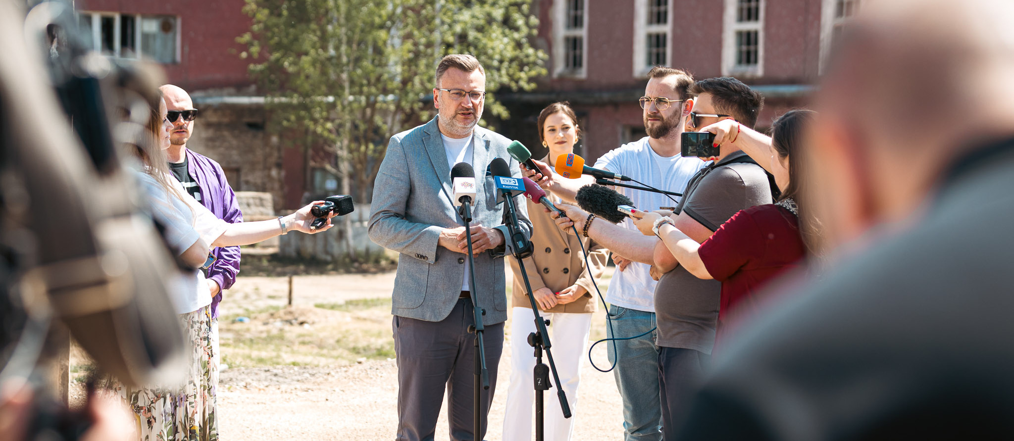 Zastępca Prezydenta Rafał Rudnicki udziela wywiadu do mikrofonów, obok stoją dziennikarze