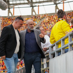 Trener Michał Probierz oraz trener Adrian Siemieniec rozmawiają ze sobą, w tle kibice na trybunach