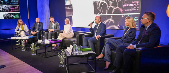 Przedstawiciele miast tworzących festiwal siedzą na kanapach w trakcie konferencji