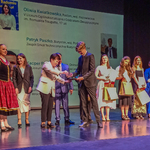 Patryk Paszko odbiera nagrodę na scenie podczas wydarzenia, w tle inni laureaci konkursu