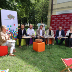 Zastępca Prezydenta Tomasz Klim oraz inni urzędnicy siedzą na zewnątrz podczas konferencji 
