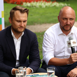 Marszałek Łukasz Prokorym z mikrofonem w dłoni siedzi obok Posła na Sejm Rzeczypospolitej Polskiej Krzysztofa Truskolaskiego