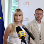 Aleksandra Pietruk oraz Paweł Pietruk stoją podczas spotkania, na pierwszym planie mikrofony