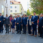 Prezydent Tadeusz Truskolaski oraz goście obecni podczas wydarzenia stoją obok budynku przy ul. Lipowej