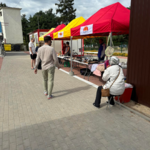Białostoczanie spacerują obok straganów pod namiotami 