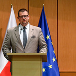 Zastępca prezydenta Tomasz Klim przemawia stojąc przy mównicy, w tle flagi Polski i Unii Europejskiej