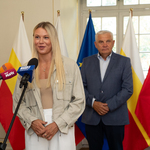 Natalia Maliszewska przemawia do mikrofonu, w tle stoi prezydent Tadeusz Truskolaski