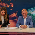 Prezes Grupy Chorten Krzysztof Pakuła, wiceprezes Grupy Chorten Sylwia Władyko siedzą przy stole i podpisują dokumenty 