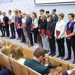 Podczas uroczystości wręczenia stypendiów prezydent Tadeusz Truskolaski stoi z uczniami na scenie auli