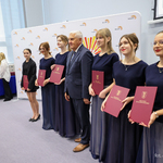 Sześć uczennic w długich granatowych spódnicach stoi z prezydentem Tadeuszem Truskolaskim 
