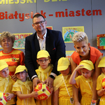 Dzieci w żółtych czapeczkach stoją razem z zastępca prezydenta Tomaszem Klim oraz kuratorem podlaskim Agnieszką Krokos-Janczyło