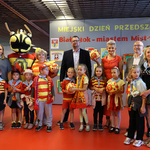 Grupa przedszkolaków z piłkami i szalikami w barwach Jagiellonii stoi razem z opiekunem, zastępcą prezydenta Tomaszem Klim i kuratorem podlaskim Agnieszką Krokos-Janczyło