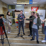 Zastępca prezydenta Rafał Rudnicki udziela wywiadu do mikrofonów, obok stoją dziennikarze i operator z kamerą