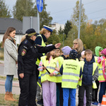 Uczniowe z odblaskami przechodzą przez przejście dla pieszych