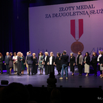 Wyróżnieni nauczyciele stoją na scenie, w tle wyświtlana grafika 