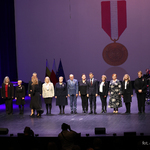Nagrodzeni medalami nauczciele stoją na scenie z wojewodą Jackiem Brzozowskim