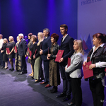 Nauczyciele stoją z listami gratulacyjnymi w rękach, po środku stoi prezydent Tadeusz Truskolaski