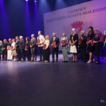 Prezydent Miasta Białegostoku stoi na scenie z nauczycielami wyróżnionymi podczas uroczystości 