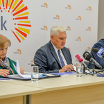Prezydent Tadeusz Truskolaski siedzi przy biurku mówi do mikrofonu, obok siedzą inni uczestnicy konferencji