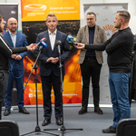 Prezes Podlaskiego Związku Piłki Nożnej Sławomir Kopczewski mówi do mikrofonów podczas konferencji, obok stoją inni uczestnicy 