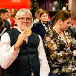 Dyrektor Muzeum Pamięci Sybiru Wojciech Śleszyński siedzi wśród innych uczestników wydarzenia i trzyma w dłoni medal.