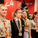 Młode kobiety odznaczone medalami w harcerskich strojach stoją obok siebie.