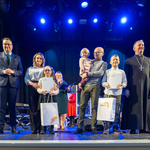 Laureaci konkursu stoją na scenie, po jednej stronie stoi zastępca prezydenta Rafał Rudnicki, po drugiej stronie stoi duchowny.