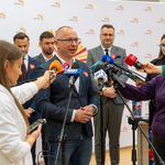 Mężczyzna udziela wywiadu do mikrofonów podczas konferencji.