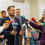 Poseł Krzysztof Truskolaski udziela wywiadu do mikrofonów trzymanych przez dziennikarzy.