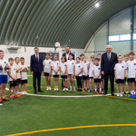 Grupa młodych zawodników z trenerem stoi razem z Prezydentem Tadeuszem Truskolaskim i kilkoma innymi uczestnikami.