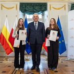 Dwie uczennice trzymają listy gratulacyjne i stoją razem z prezydentem Tadeusz Truskolaskim.