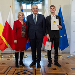 Kobieta i wyróżniony uczeń stoją razem z prezydentem Tadeuszem Truskolaskim.
