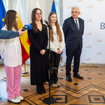 Trzy uczennice stoją przed mikrofonem, obok stoi Prezydent Miasta Białegostoku.